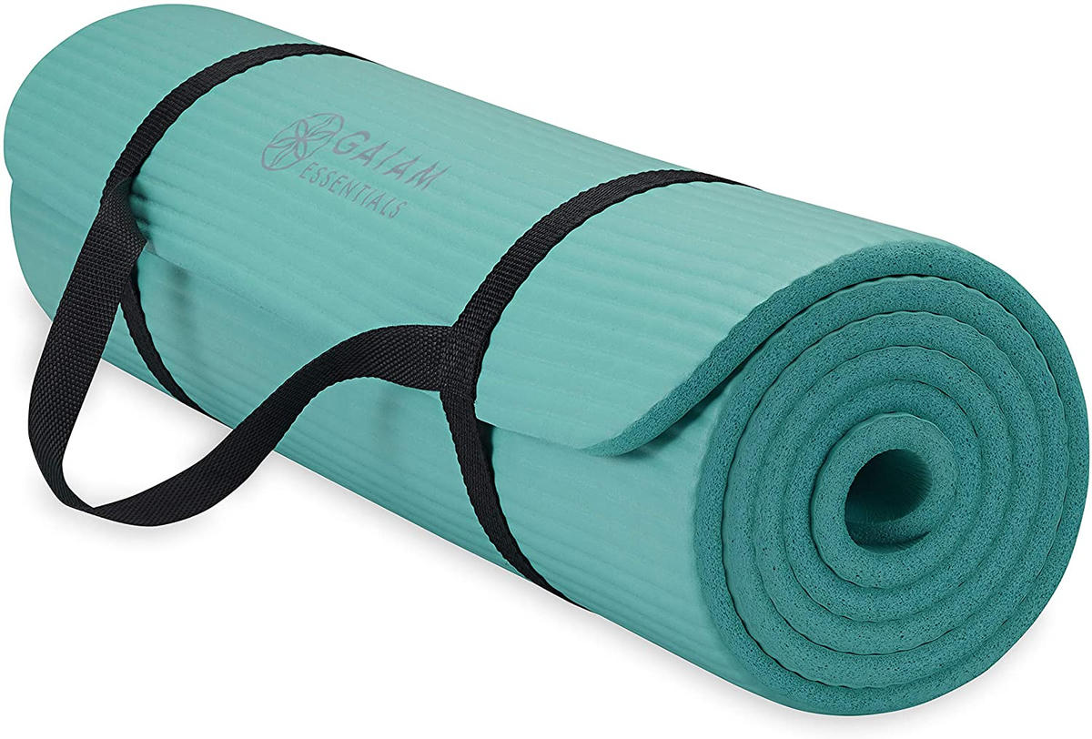 Gaiam Essentials yoga and exercise mat partly rolled, with a carry strap
